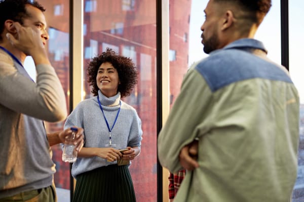 Young adults engaged in conversation in a professional setting.